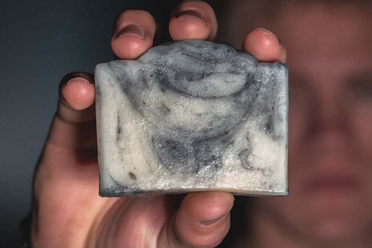 manly fingers holding soap up into view