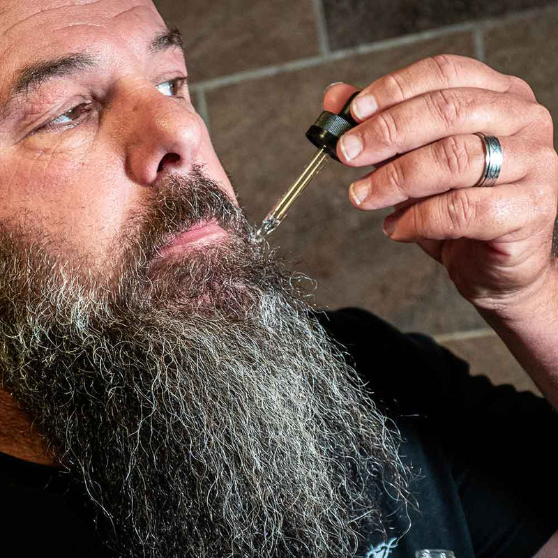 beard oil being applied to a man's beard